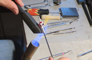 Pressing dots of red-hot glass into a bead