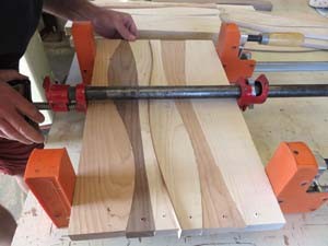 Pieces of cherry, maple, and oak are clamped securely together while  waterproof glue dries at Mike Wilkinson's workshop.