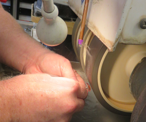 Ryan Gardner shapes an amethyst on a diamond grinding wheel